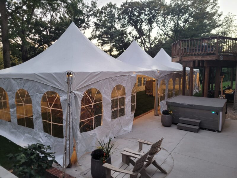 a white tent with windows and a deck