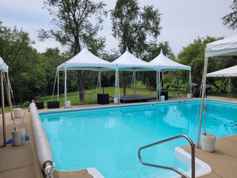 a pool with white tents and trees
