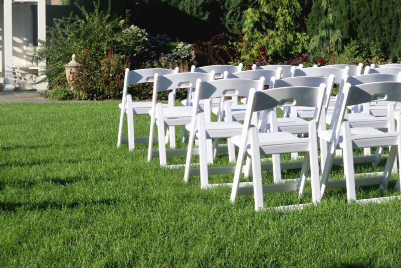 a group of white chairs in a grassy area