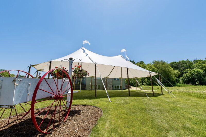 a white tent with a red wheel in front of a house